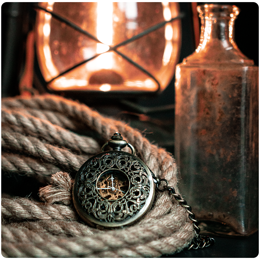 Moody product still life of an ornate pocket watch resting on coiled rope beside a glass bottle and warm lantern glow